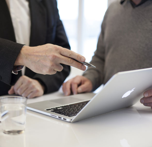 Two investors reviewing a commercial property deal on a laptop